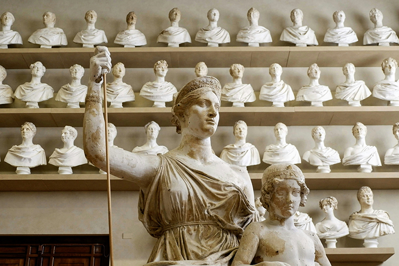 Marble busts in storage behind a statue