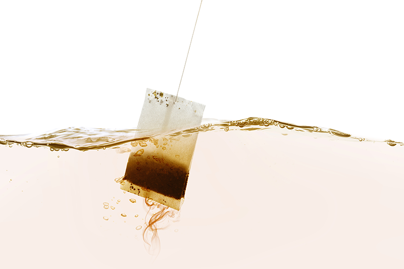 Stock image of a teabag being dipped in water