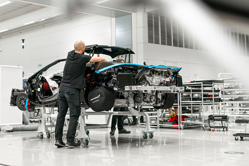 A McLaren automotive workshop with someone working on a model