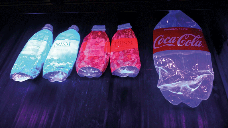 Bottles with the PolyPRISM labels under  ultra-violet light