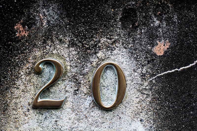 brass coloured numbers on a textured stone surface 2 and 0