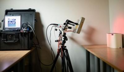 The laser shearography setup includes a tripod stand in the middle with camera mount, lasers and halogen lamps