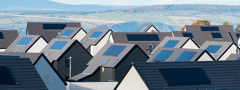 Stock image of rooftop solar panels across multiple houses