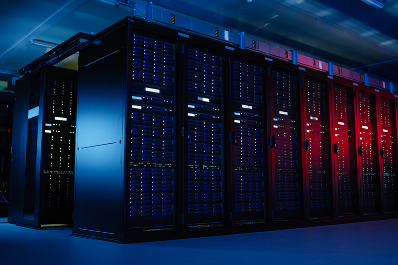 Stock image of operational data centre service racks in a dark room