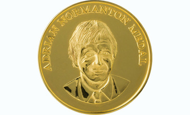 raised lettering reads Adrian Normanton Medal at the top of a gold circulat medal, beneath is a depiction of Normanton