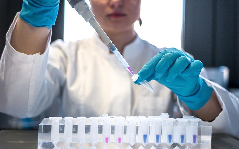 Researcher with a pippette and sample tubes in a rack